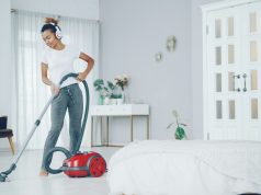 zena-sa-usisivacem-pored-kreveta